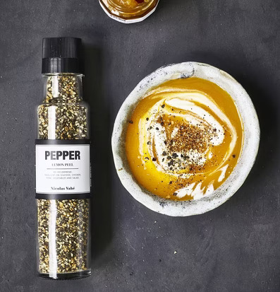 Bild av kryddkvarn och soppa med elegant presentation