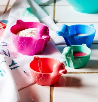 Bild av färgglada mätskopor i hemtrevlig köksmiljö