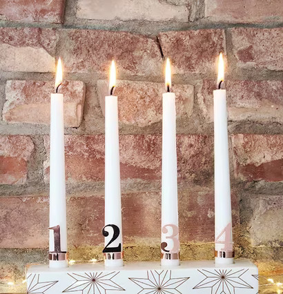 Adventsljusstake Stjärna från Pluto Produkter framför tegelvägg