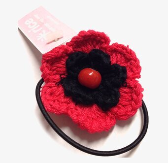 Bild av stilren hårsnodd med röd och svart blomma