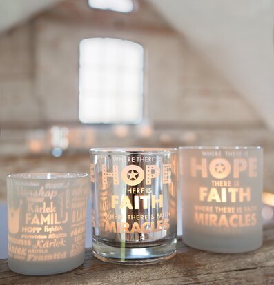 Bild av tre ljuslyktor på rustik yta med inspirerande ord