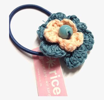 Bild av färgglad hårsnodd med blomdetalj i dimblå/aprikos