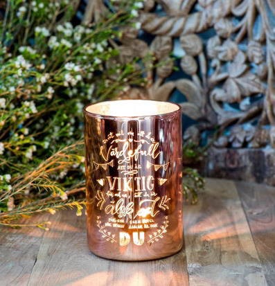 Bild av elegant ljuslykta i roséguld med varm glöd