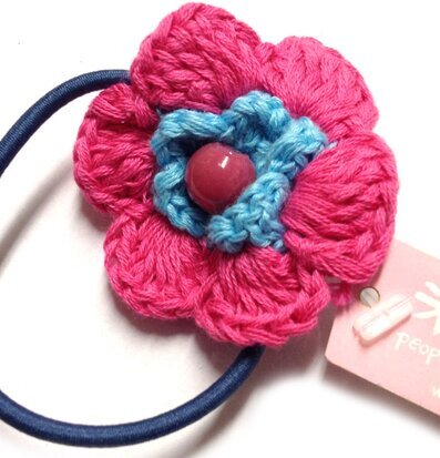 Bild av färgglad hårsnodd med blomdesign och pärldetalj