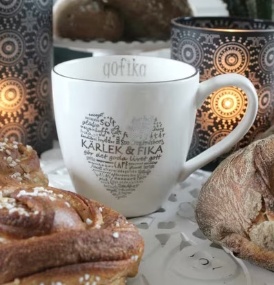 Bild av mysig fika med stilren mugg och ljuslyktor