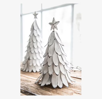 Bild av vit julgran i metall med stjärna och skuggor