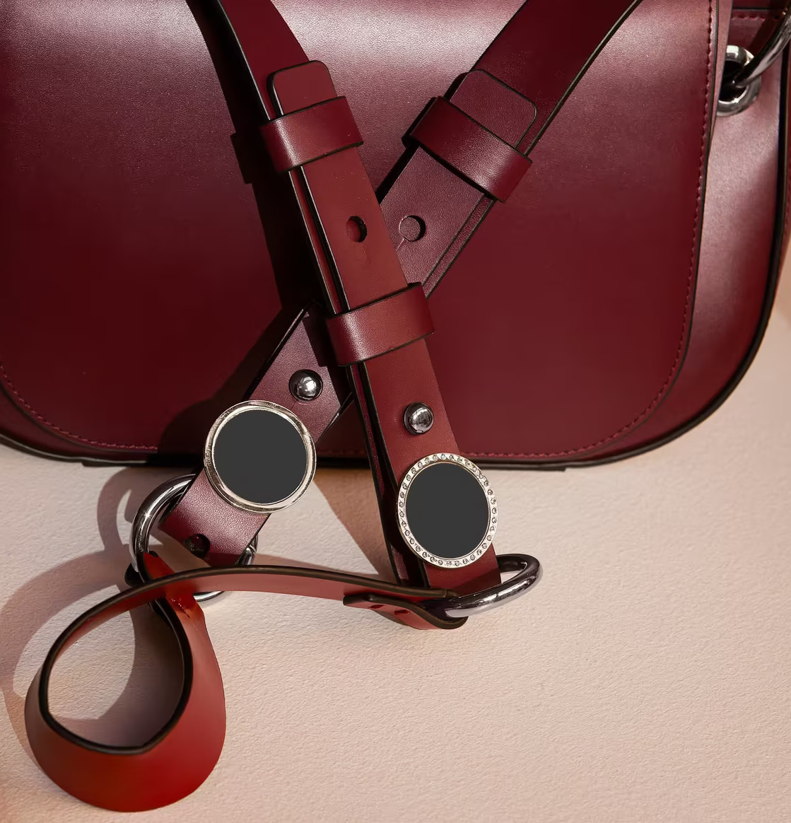 Reflexbrosch Silver Stenar från Firefly på rödvinsläderväska