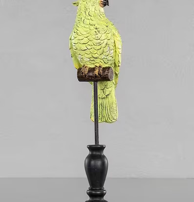 Bild av grön kakadua skulptur på elegant piedestal