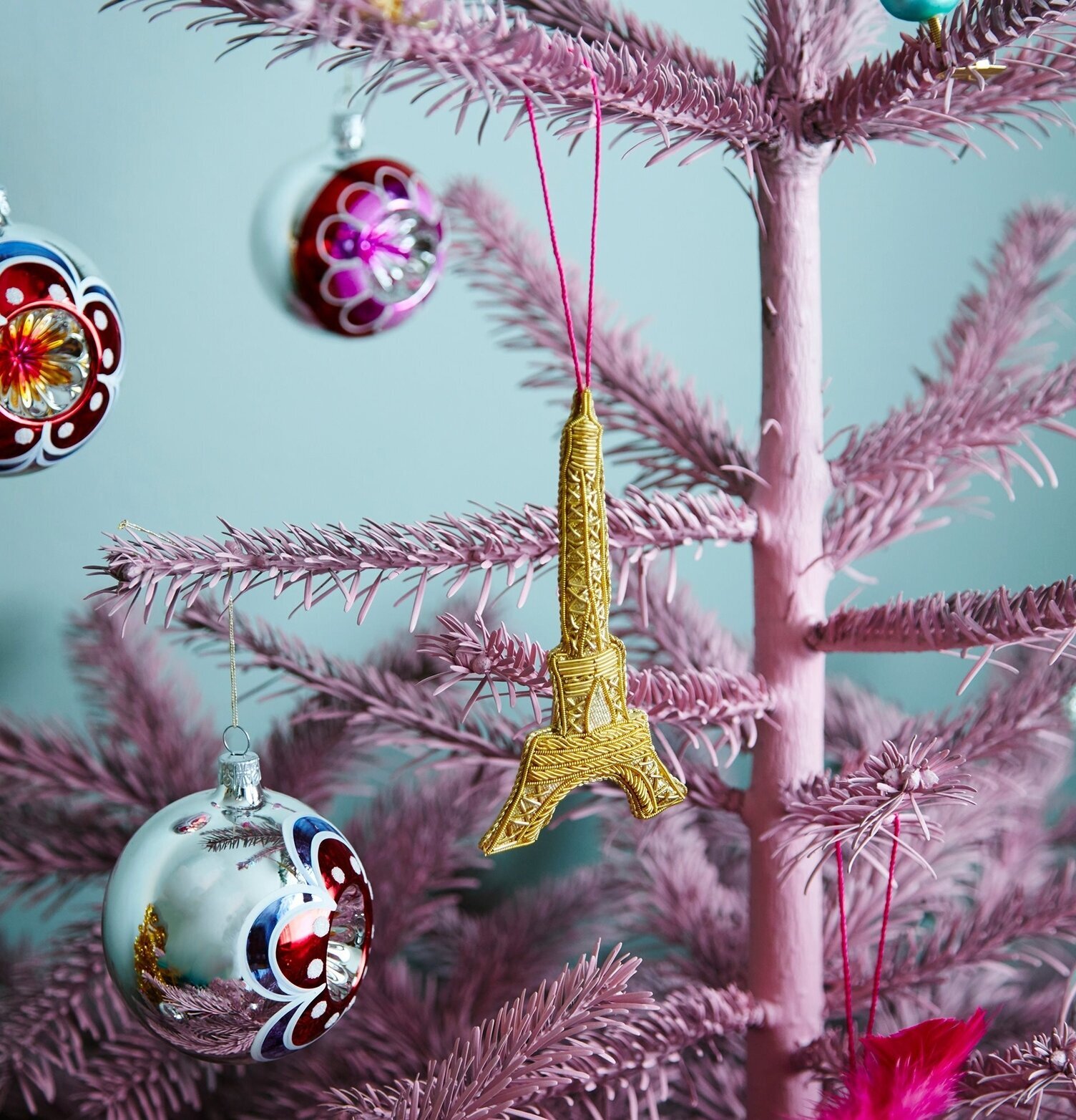 Bild av julgranskula och Eiffeltornet i rosa gran