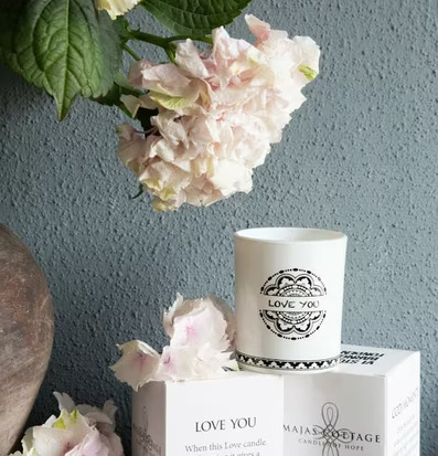 Bild av smakfullt arrangemang med doftljus och blommor