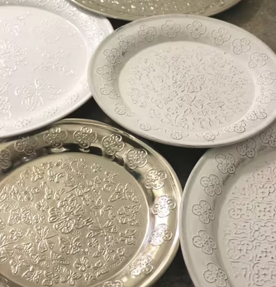 Foto av elegant arrangerade metallfat med fjärilsmönster