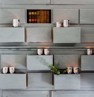 Bild av elegant vägginstallation med ljus och böcker