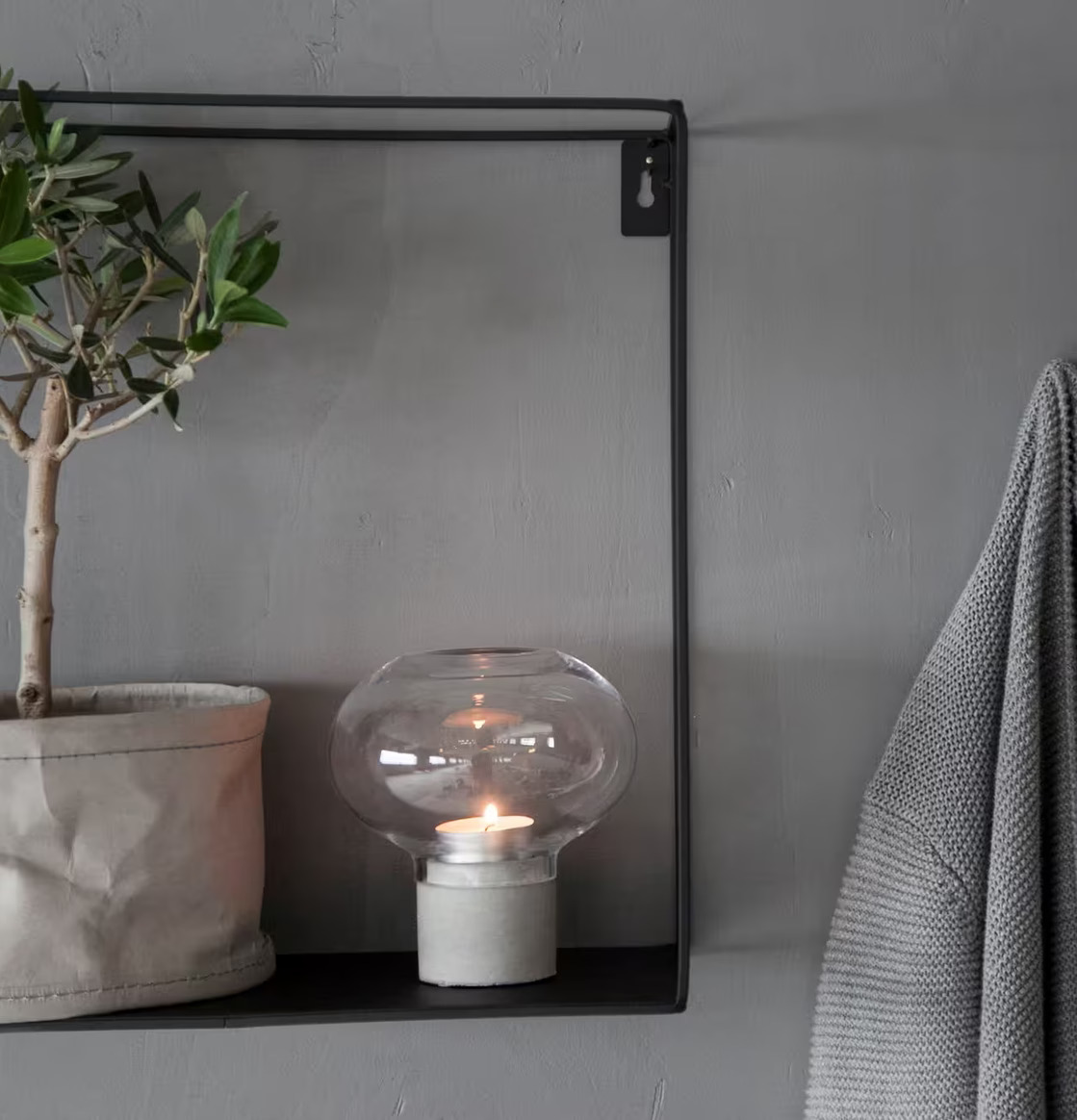 Bild av stilren hylla med växt och ljusstake i hemmet