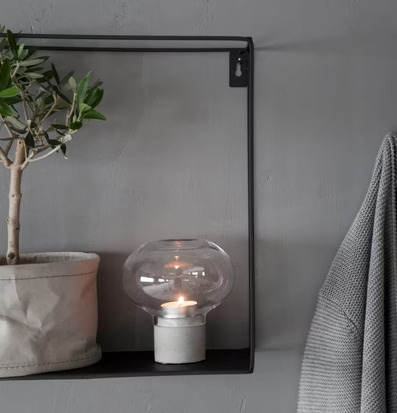 Bild av stilren hylla med växt och ljusstake i hemmet