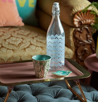 Bild av sängbricka i rosa och guld med elegant design