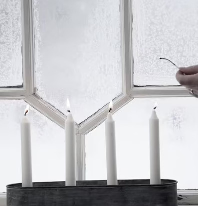 Bild av adventsljusstake i vinterlandskapets sken