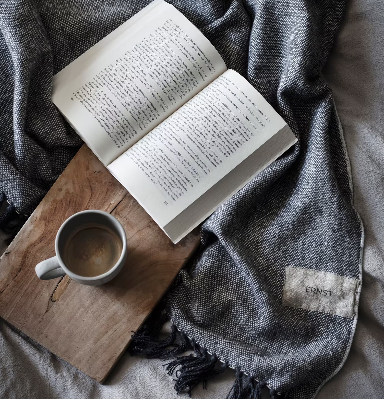 Bild av pläd, bok och kopp i harmonisk komposition