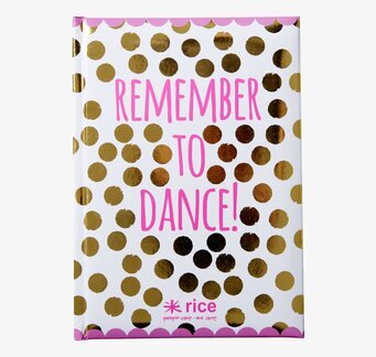 Bild av anteckningsbok med gyllene prickar och rosa text