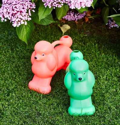 Bild av färgglada, pudelformade vattenkannor i trädgård